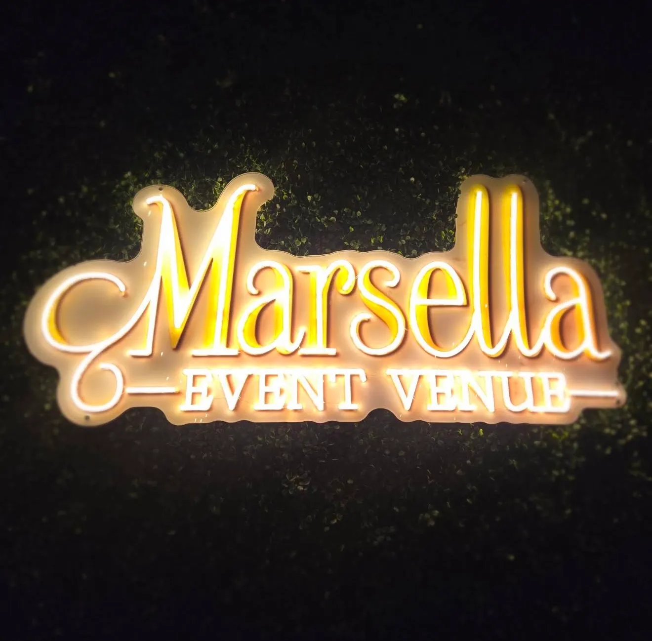 The Marsella Event Venue neon sign on the greenery wall